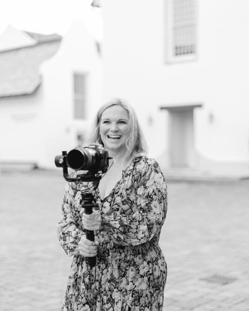 katherine denise wedding videographer at rosemary beach, fl in floral dress holding a gimbal.