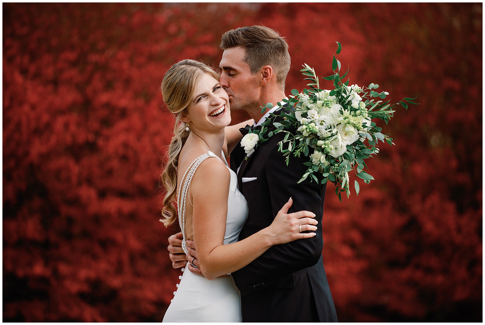 gorgeous red leaves behind bride and groom at the crest center october wedding photo by kathy beaver wedding film by Katherine Denise FIlms